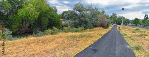 Views of Jordan River Trail with surrounding trees  Russian Olive  cottonwood and silt filled muddy water along the Wasatch Front Rocky Mountains  in Salt Lake City  Utah.