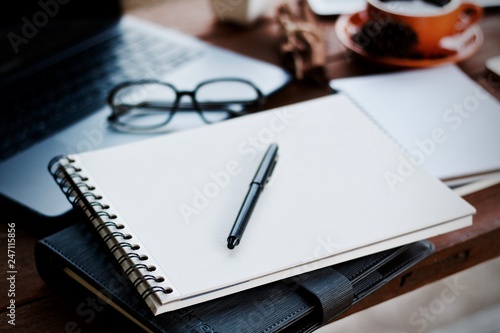 notebook and pen on wooden table