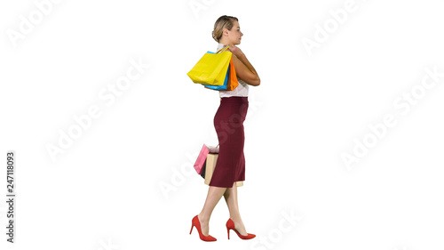 Happy shopping! Womanholding multicolored shopping bags and walking on white background. photo