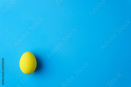 happy easter, spring holidays, greeting card or festive banner template. yellow painted colored egg on blue background