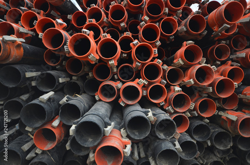 background of plastic rubber pipes. Large Group and Stack of orange and black Plumbing plastic rubber pipes. Industrial Plastic irrigation Pipes Full Frame Background.