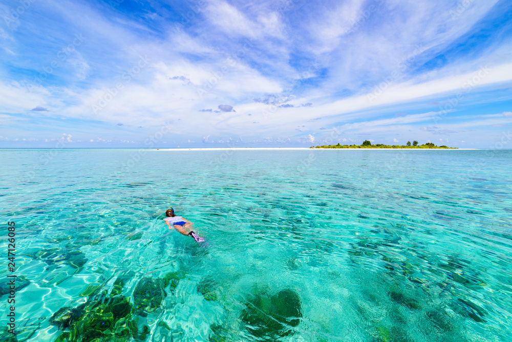 Woman snorkeling on coral reef tropical caribbean sea, turquoise blue water. Indonesia Wakatobi archipelago, marine national park, tourist diving travel destination Woman snorkeling on coral reef tropical caribbean sea, turquoise blue water. Indonesia Wakatobi archipelago, marine national park, tourist diving travel destination