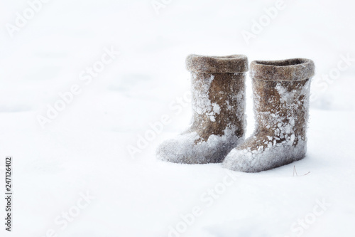 felt boots standing on the snow stained with snow © SatrianiPh 