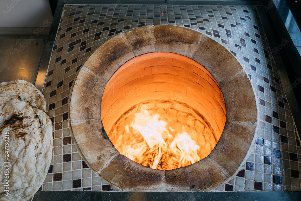 Traditional turkish wood fired stone brick oven and pita or pide bread  dough. This stone oven for Turkish pide or pita bread. Also known as Tandır  or Tandir Stock Photo