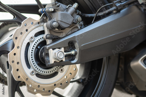 Closeup detail of sport racing motorcycle wheel and ABS brakes system with aluminium swingarm 220 mm rear disc 1 piston caliper stopping power ABS fitted as standard.