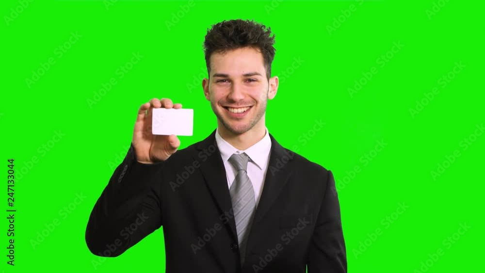 Smiling business man showing business card, isolated on green screen chroma key background Smiling business man showing business card, isolated on green screen chroma key background