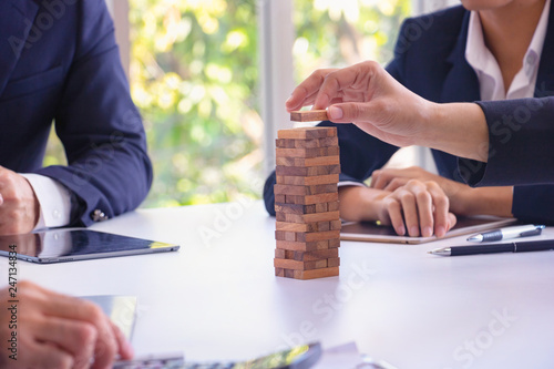 Body part Business engineers plays Jenga game and Orange hat. They are sitting in office and play game.Photo concept for engineering  and work.