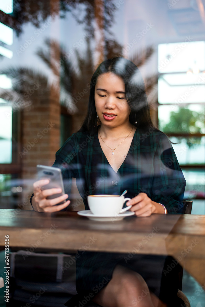 Girl having coffee and using phone in the bar Girl having coffee and using phone in the bar