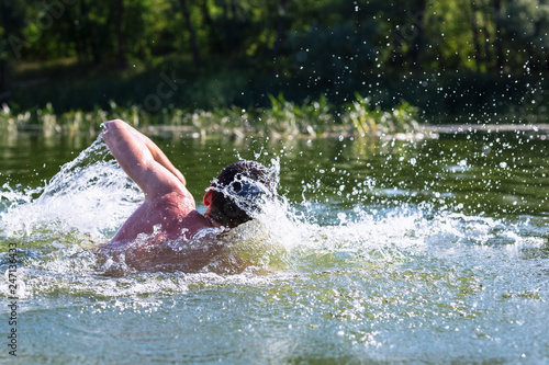 Fototapeta Naklejka Na Ścianę i Meble -  The young man swimming in the river