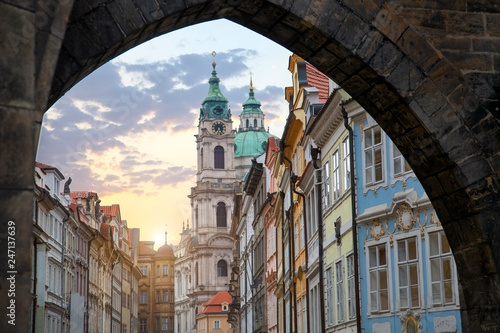 view of the city of Prague through the old arch. Tourist theme. Old town in the evening with the sunset sun