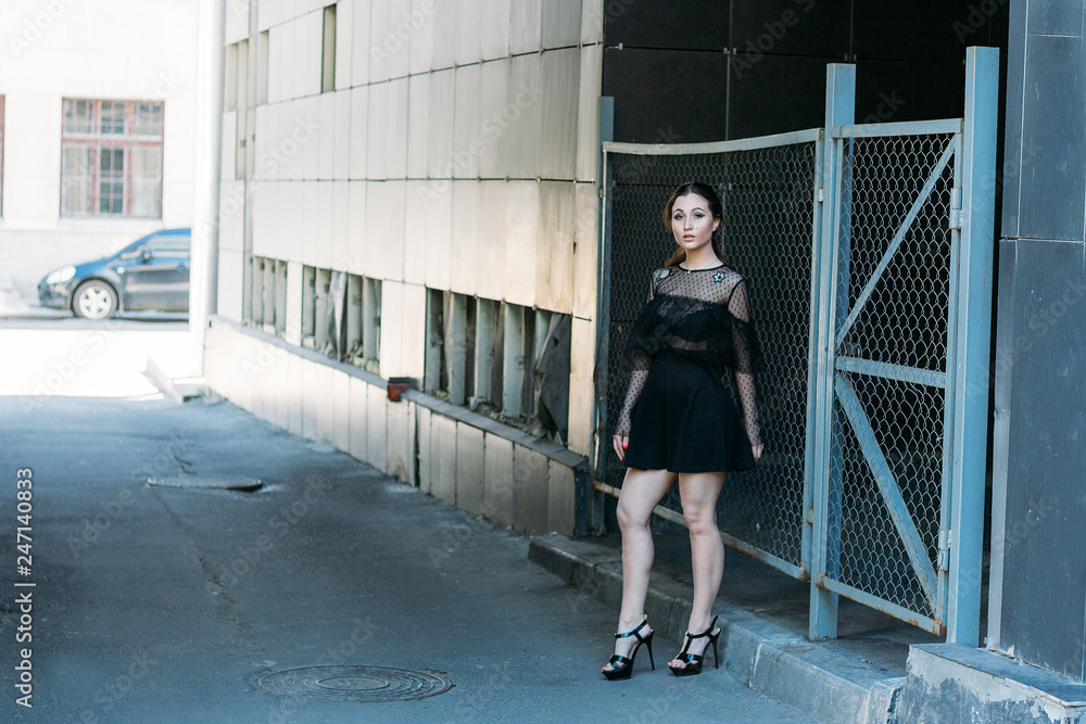 portrait of a girl, brunette, in a black dress, in the arch, in the city. posing, walking. alone in the crowd, loneliness portrait of a girl, brunette, in a black dress, in the arch, in the city. posing, walking. alone in the crowd, loneliness