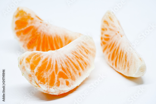 Ripe and juicy tangerine slices on a white background.