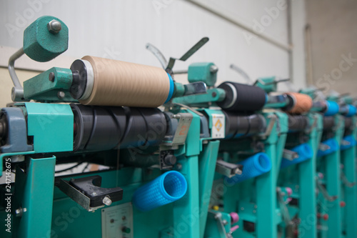 Group of bobbin thread cones on a warping machine in a textile mill. Yarn ball making in a textile factory. Textile industry - yarn spools on spinning machine in a textile factory