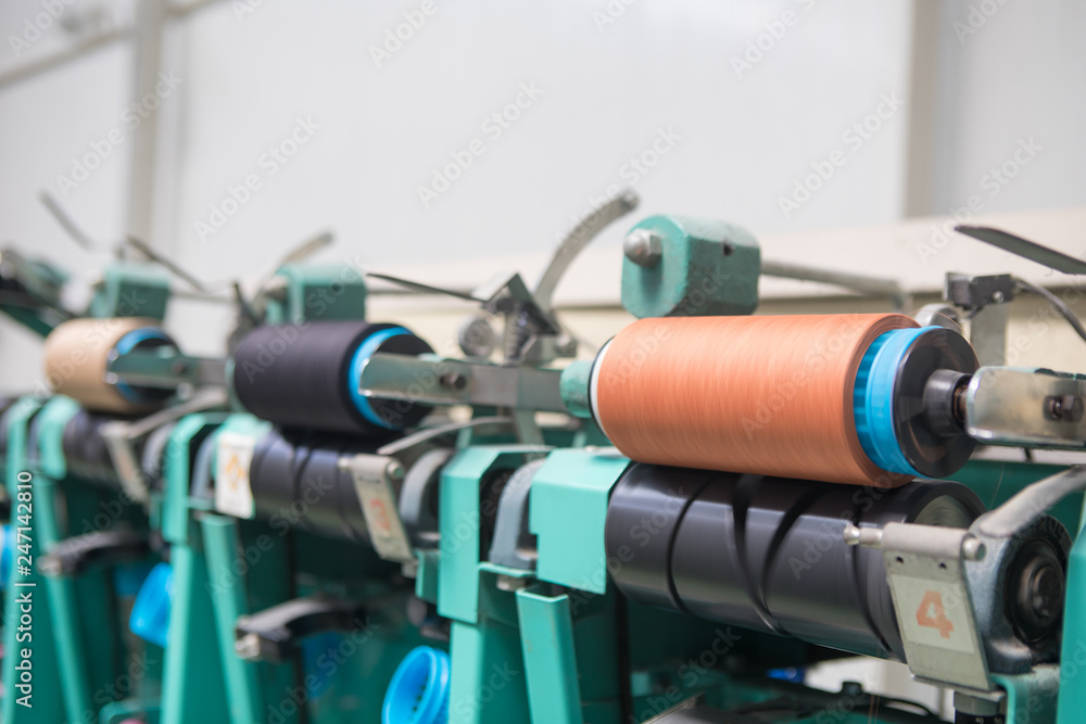 Group of bobbin thread cones on a warping machine in a textile mill. Yarn ball making in a textile factory. Textile industry - yarn spools on spinning machine in a textile factory Group of bobbin thread cones on a warping machine in a textile mill. Yarn ball making in a textile factory. Textile industry - yarn spools on spinning machine in a textile factory