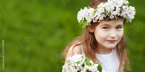 Beautiful young girl in white dress in the garden with blosoming  apple trees. Smiling girl  having fun and enjoying. Copy space photo