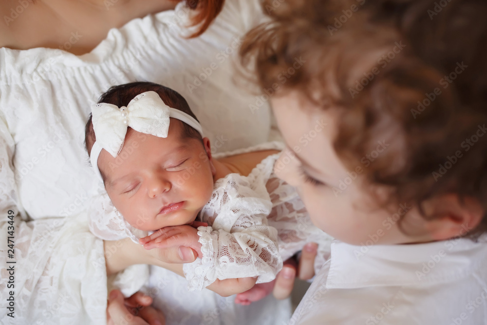 Mother and brother looking at a cute newborn girl