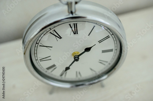a silver vintage clock on the nighstand