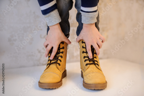 close up photo of a boy's legs in yellow leather child shoes on vintage background