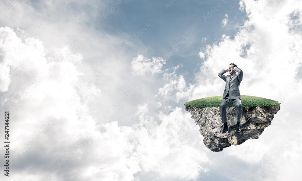 Young man on floating island do not want to hear anything Young man on floating island do not want to hear anything