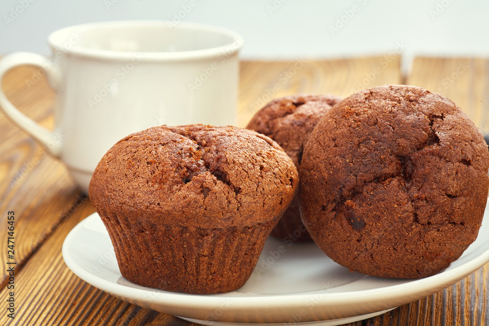 Dark chocolate dough muffin on the background of an old wooden table. Dark chocolate dough muffin on the background of an old wooden table.