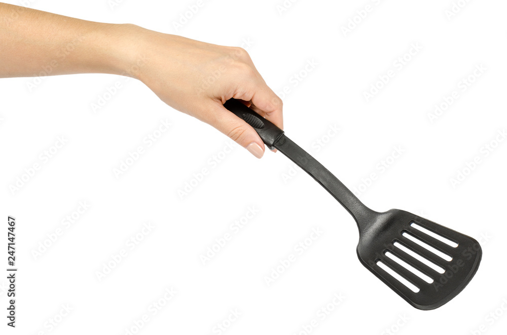 Hand with Black plastic kitchen spatula, kitchenware for cooking Stock  Photo | Adobe Stock