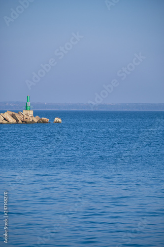 Green lighthouse by the ocean © ILIA