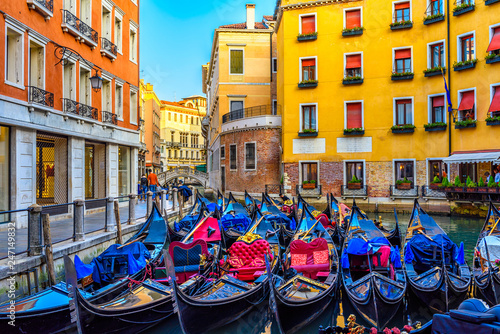 Narrow canal with gondolas and bridge in Venice, Italy. Architecture and landmark of Venice. Cozy cityscape of Venice.