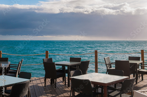 table and chairs in a restaurant by the sea