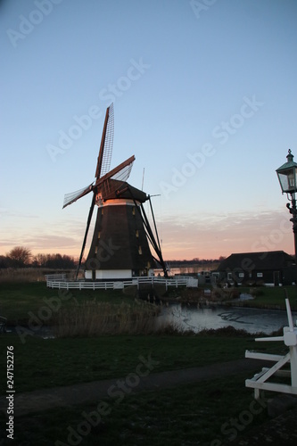 Windmill Eendragtsmolen reflection on the river Rotte at sunset in Zevenhuizen, the Netherlands photo