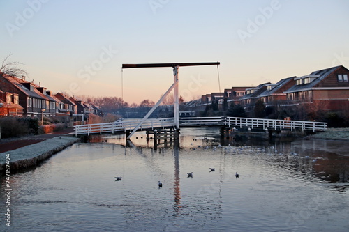 Wooden drawbridge over the ring Canal Zuidplaspolder named Kleinpolderbrug during sunrise in Nieuwerkerk aan den IJssel in the Netherlands photo