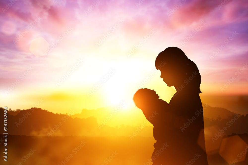silhouette of mother holding son on sunset view for mother day concept