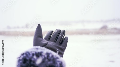 Hand touching the snowy in a snowfall