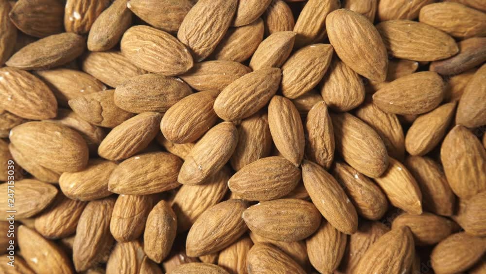 Brown almonds as natural food background or texture. Top down view. Healthy food, good for heart health, high in magnesium mineral Brown almonds as natural food background or texture. Top down view. Healthy food, good for heart health, high in magnesium mineral