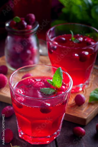 Refreshing vitamin cranberry drink in glass cups on a wooden table, selective focus