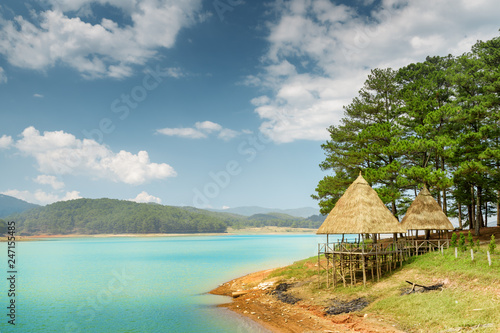 Scenic lake with azure water among green pine woods