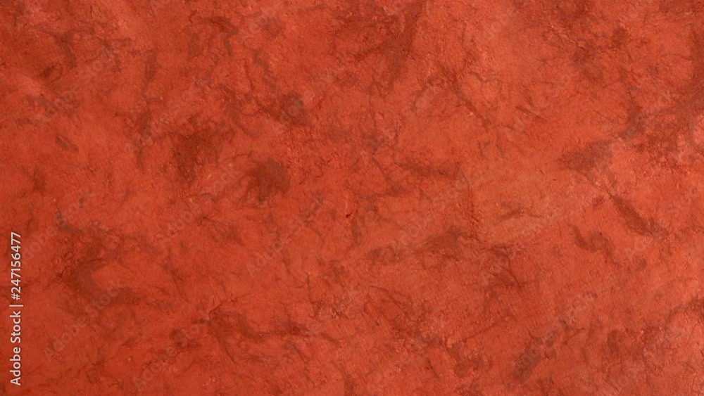 background of pumpkin red handmade Huun paper created by Mayan artisans in Mexico from a tree bark - diagonal pan background of pumpkin red handmade Huun paper created by Mayan artisans in Mexico from a tree bark - diagonal pan