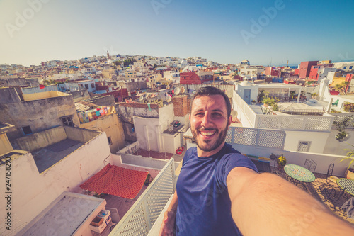 happy tourist take selfie with the cityscape of the medina of Tanger, Morocco. Colors of sunset