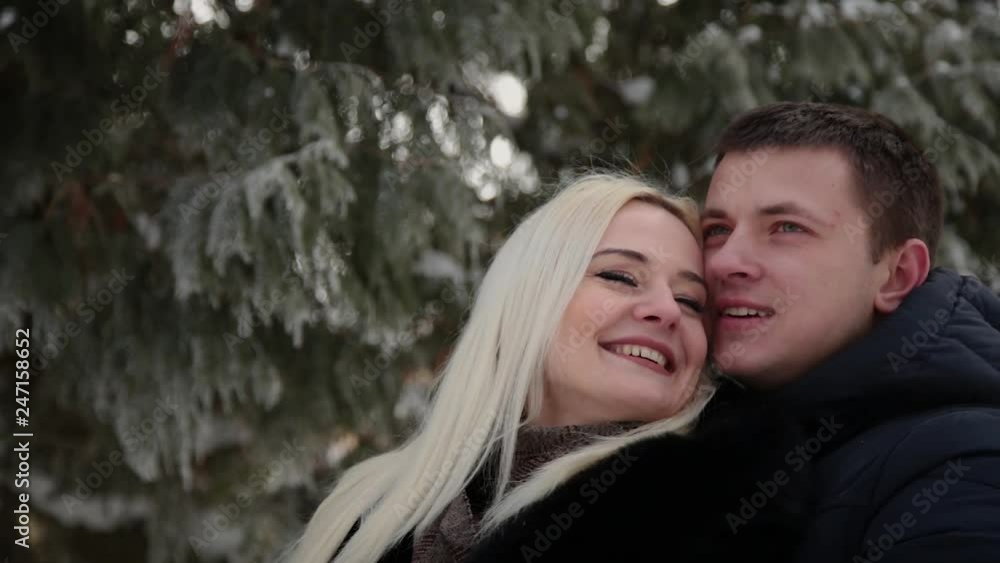 Beautiful young couple hugging and talking in a city winter park. Beautiful young couple hugging and talking in a city winter park.