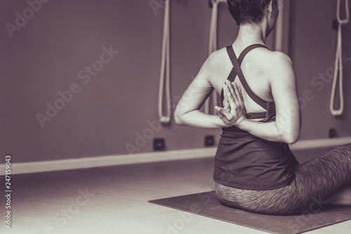 Young woman practicing yoga with namaste behind the back.working out, wearing sportswear.Calmness and relax, woman happiness. Toned picture © anon