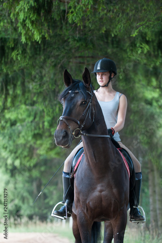 Portrait of black horse with teenage girl equestrian on it © AnnaElizabeth