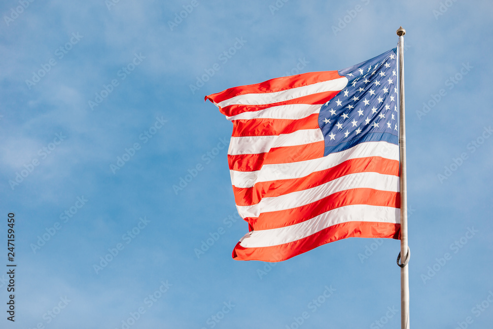Obraz premium American flag on the blue sky with clouds