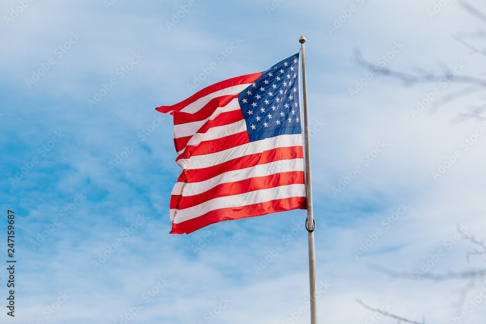 Obraz premium American flag on the blue sky with clouds