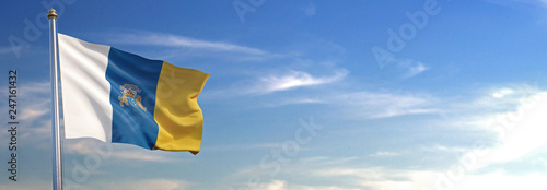 Bandera de las Islas Canarias subida ondeando al viento con cielo de fondo photo