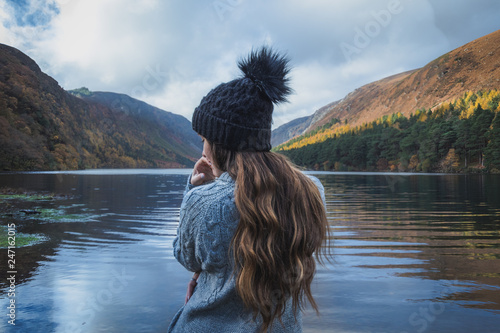 Woman standing on the edge of Upper Lake in Glendalough Ireland photo