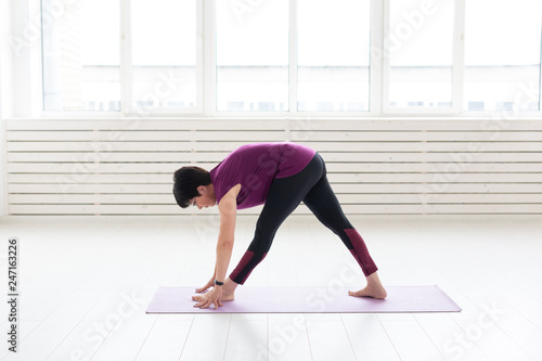 Yoga, people concept - a middle-aged woman doing a yoga and try to do a asana