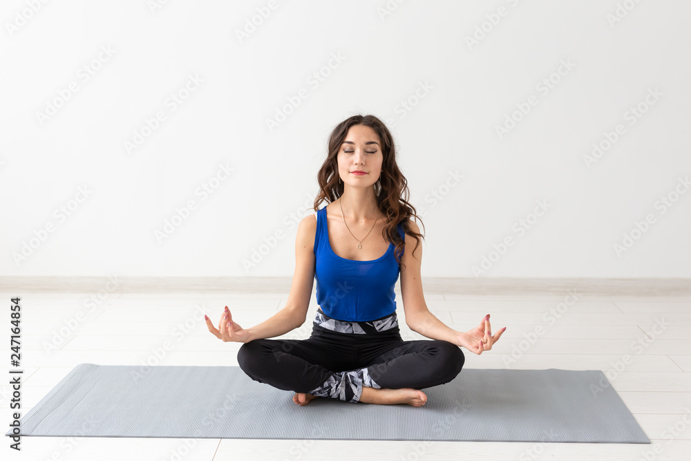 Fototapeta premium Healthy lifestyle, people and sport concept - Young woman with curly hair doing yoga over white background