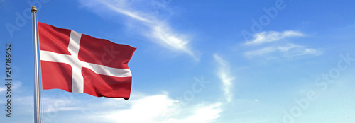 Flag of Denmark rise waving to the wind with sky in the background photo