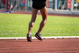 Running man's legs jogging on running track.