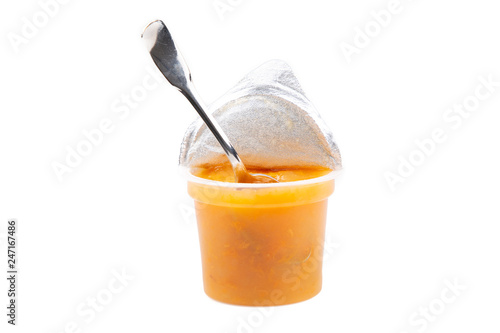 little pot and spoon for baby apricot compote in white background
