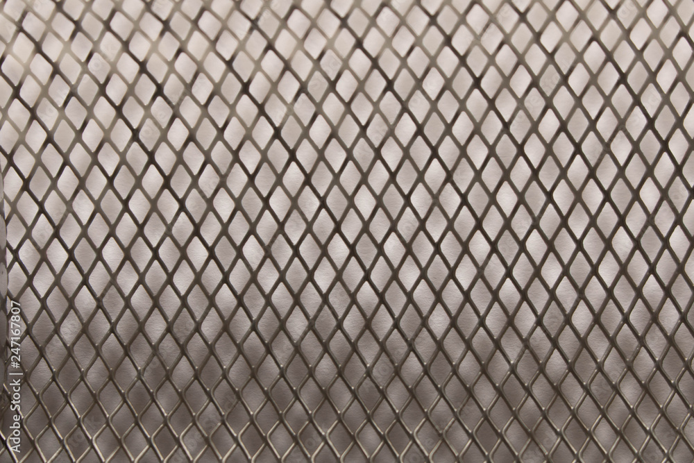 Fototapeta premium Metal mesh background texture. On white background. Close up. Selective focus.